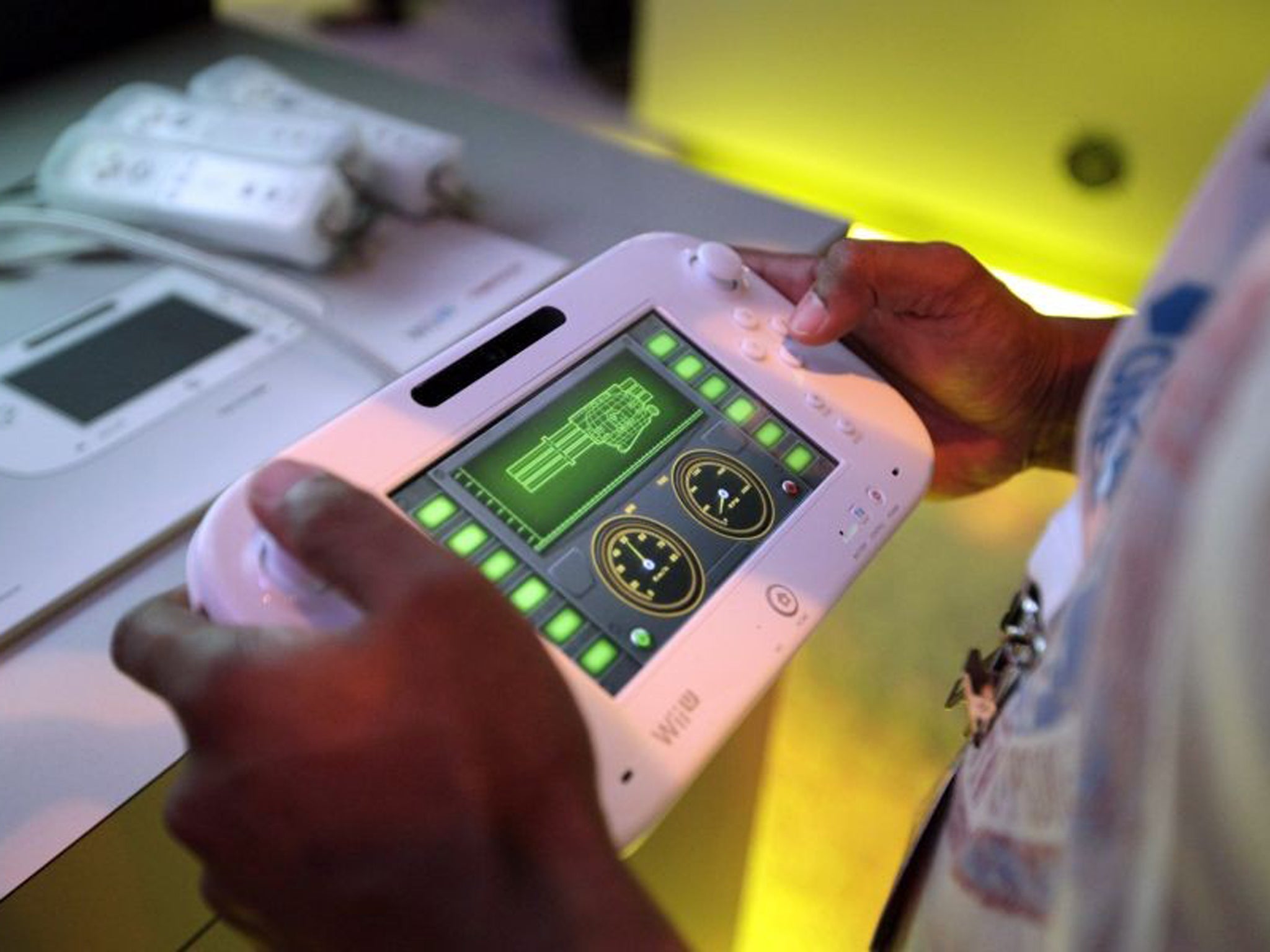 An attendee plays a video game using Nintendo's Wii U controller
