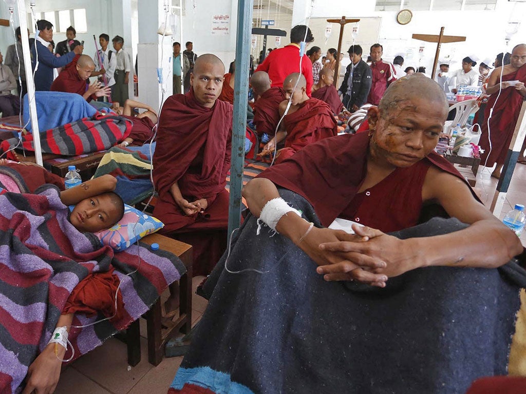 A severely burnt Buddhist monk receiving treatment after police fired water cannons and smoke bombs to break up protests