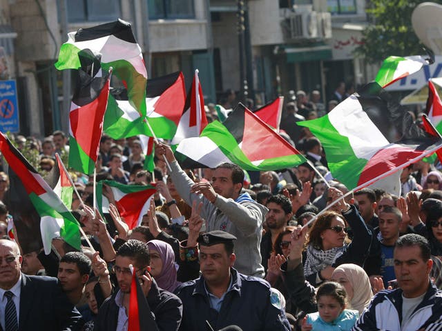 Crowds wave Palestinian flags in the West Bank city of Ramallah yesterday