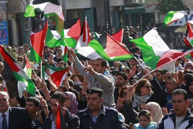 Crowds wave Palestinian flags in the West Bank city of Ramallah yesterday