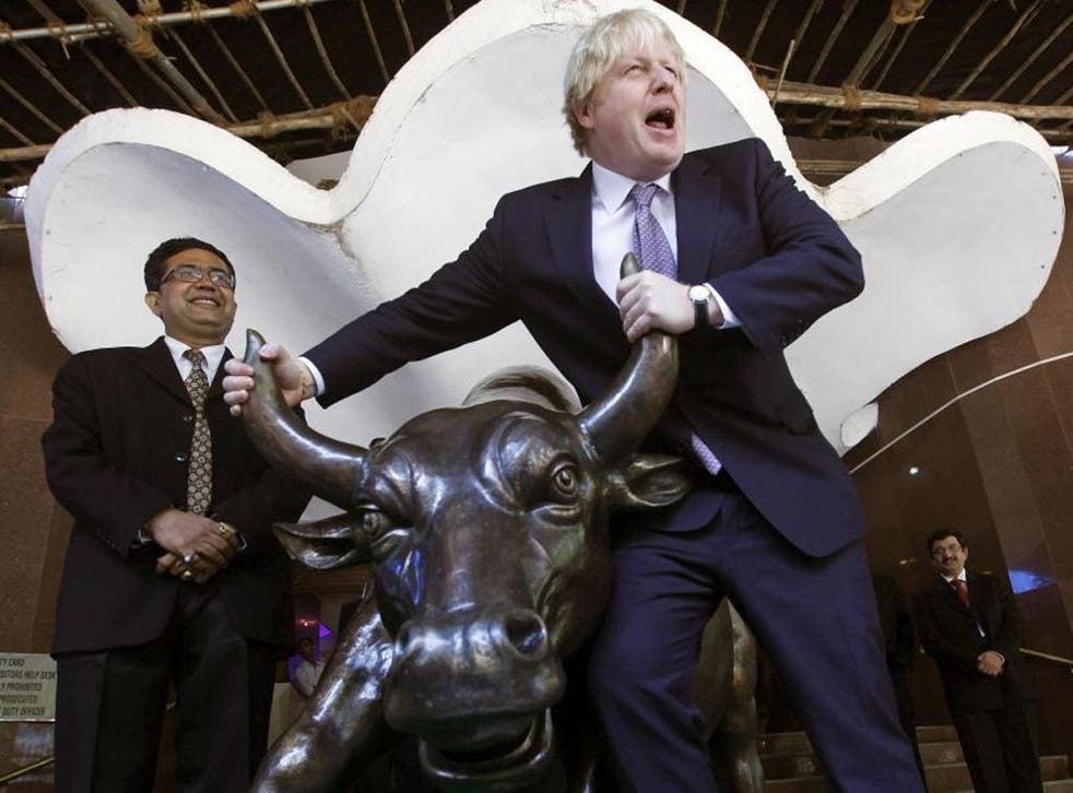 London Boris Johnson poses with the bronze statue of a bull outside the Bombay Stock Exchange