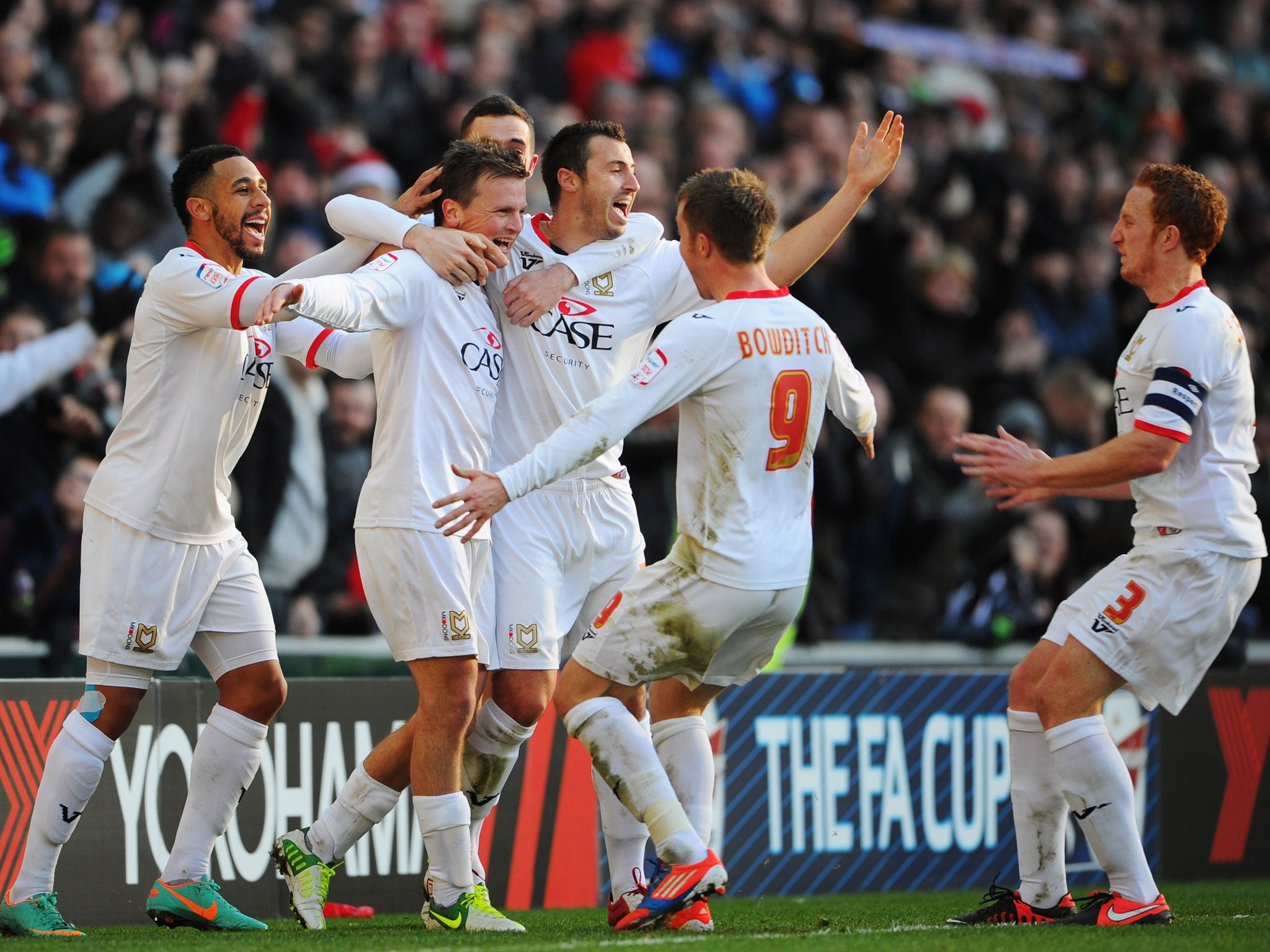Stephen Gleeson of MK Dons celebrates with team mates as he scores their first goal of the match