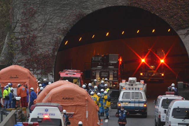 Rescue workers from police, fire department and highway authorities work at the entrance the the Sasago tunnel