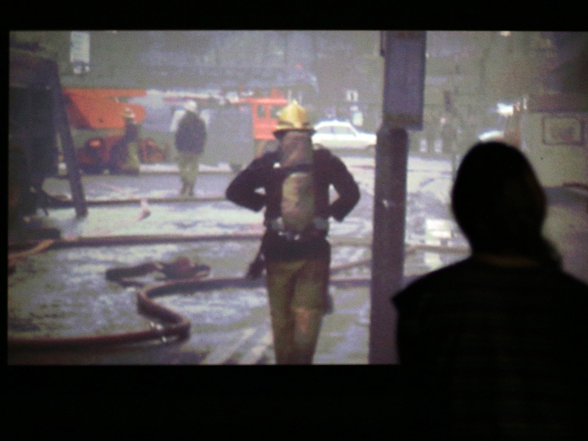 A visitor looking at Elizabeth Price's video installation 'The Woolworths Choir Of 1979 2012'