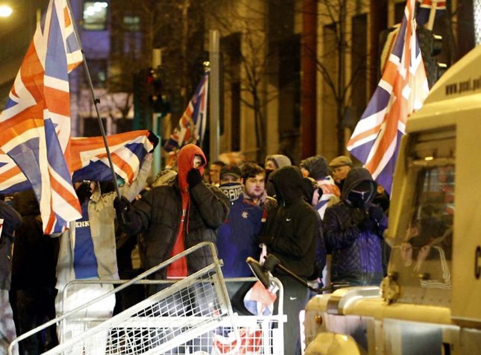 Loyalists confront Police Service of Northern Ireland officers as they try to force their way into Belfast City Hall