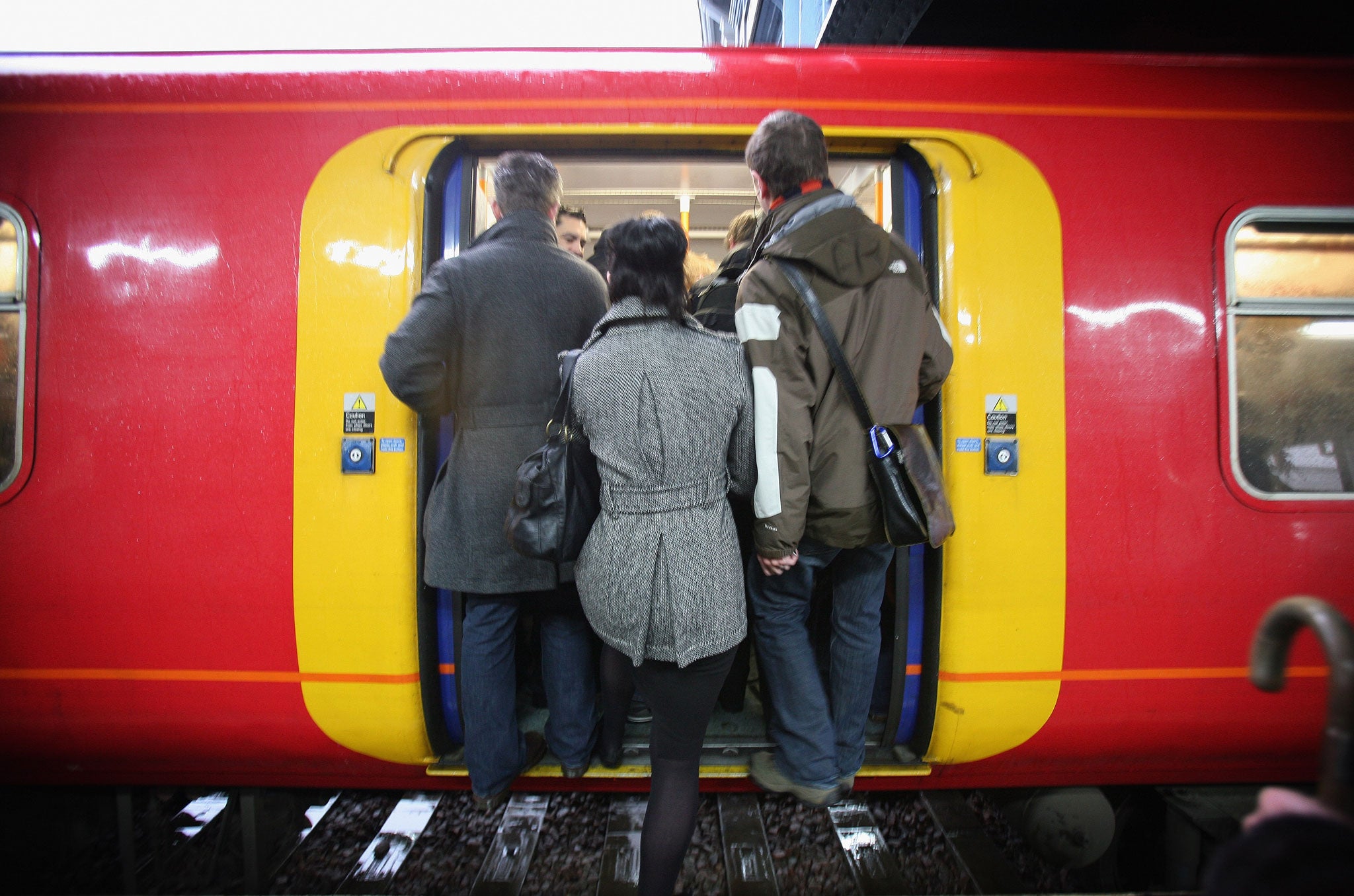 Commuters squeeze on to a train to Victoria Station at Clapham Junction on February 5, 2009 in London, England.