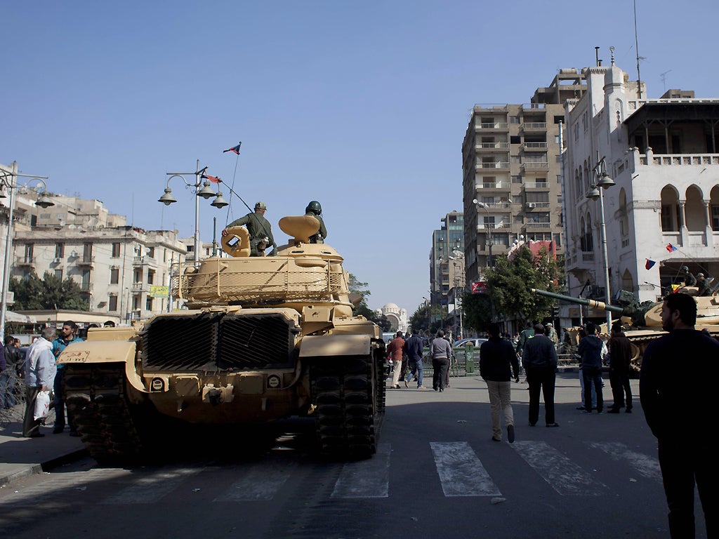 Egyptian Army tanks deploy near the presidential palace to secure the site of overnight clashes between supporters and opponents of President Mohammed Morsi in Cairo