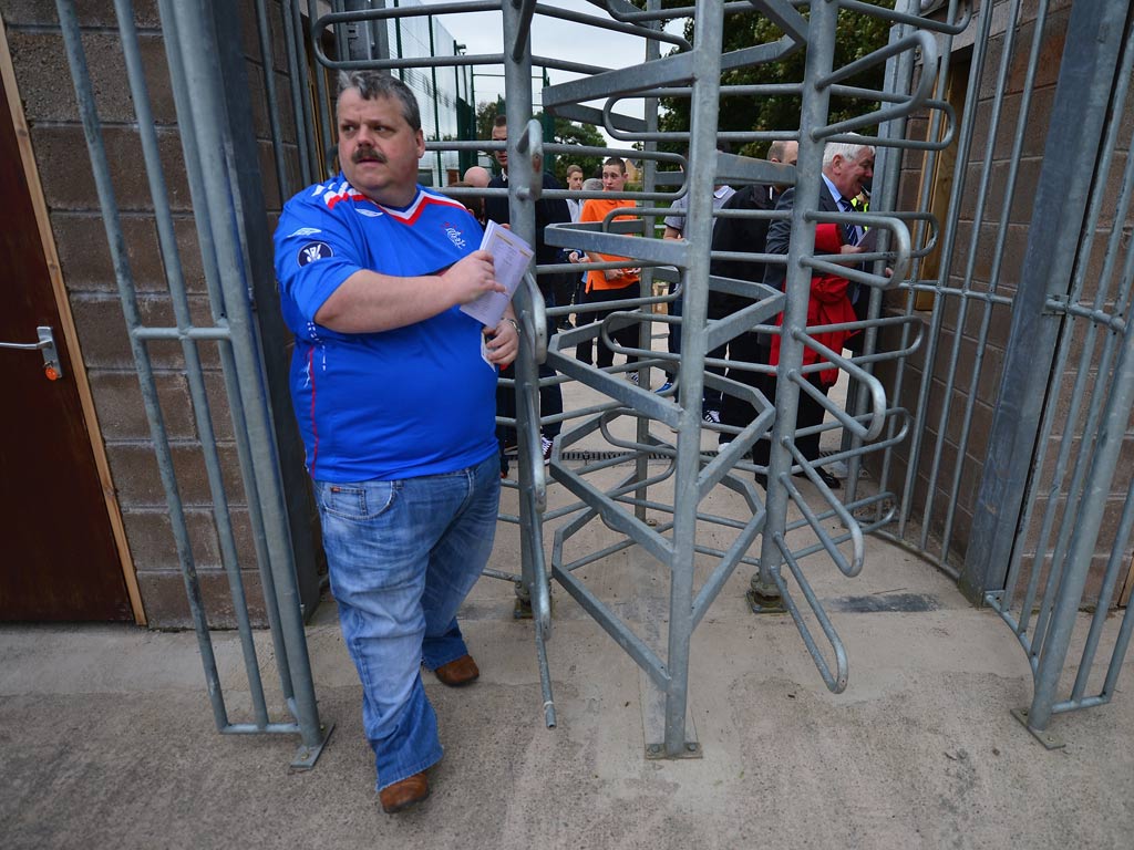 A Rangers fan passes through the turnstile