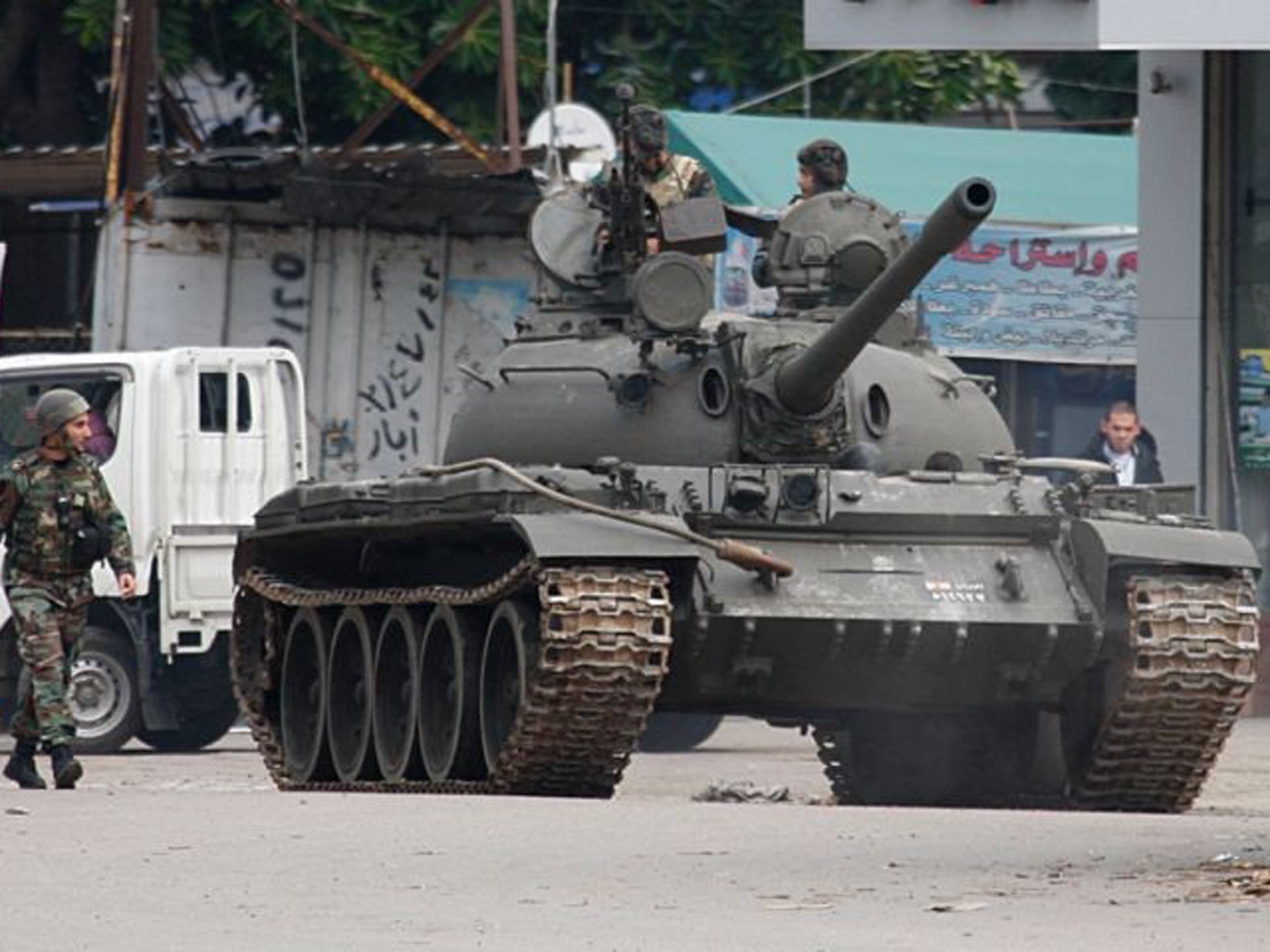 Lebanese army soldiers ride in a tank during the clashes erupted in Tripoli