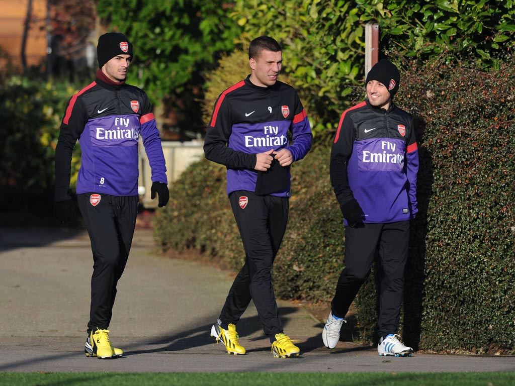 Mikel Arteta, Lukas Podolski and Santi Cazorla of Arsenal during a training session