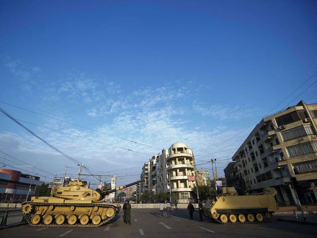 Egyptian army tanks deploy outside the presidential palace in Cairo on 8 December