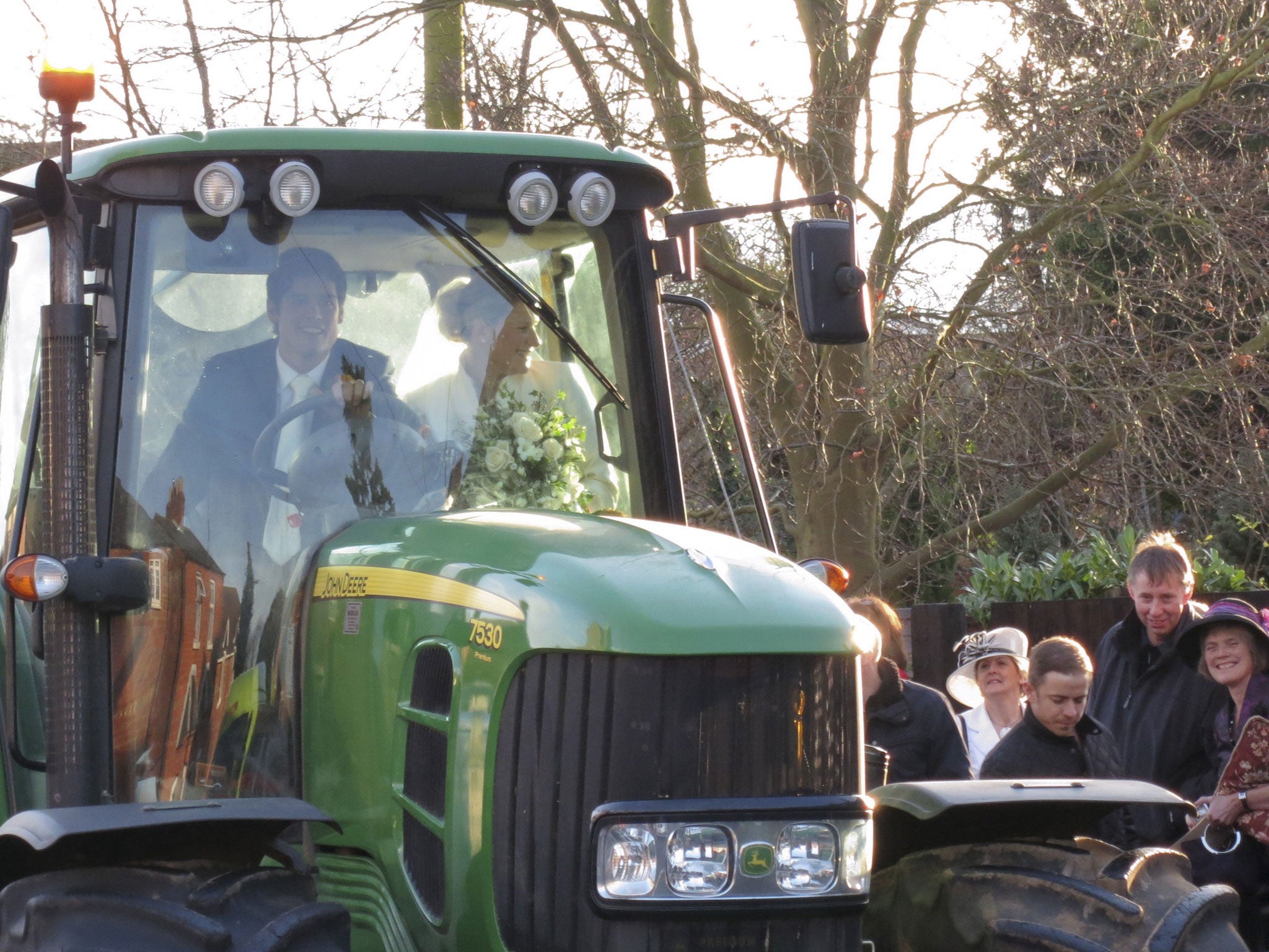 Plenty of welly: Alastair Cook draws admiring glances as he and his bride ride off in a tractor on their wedding day