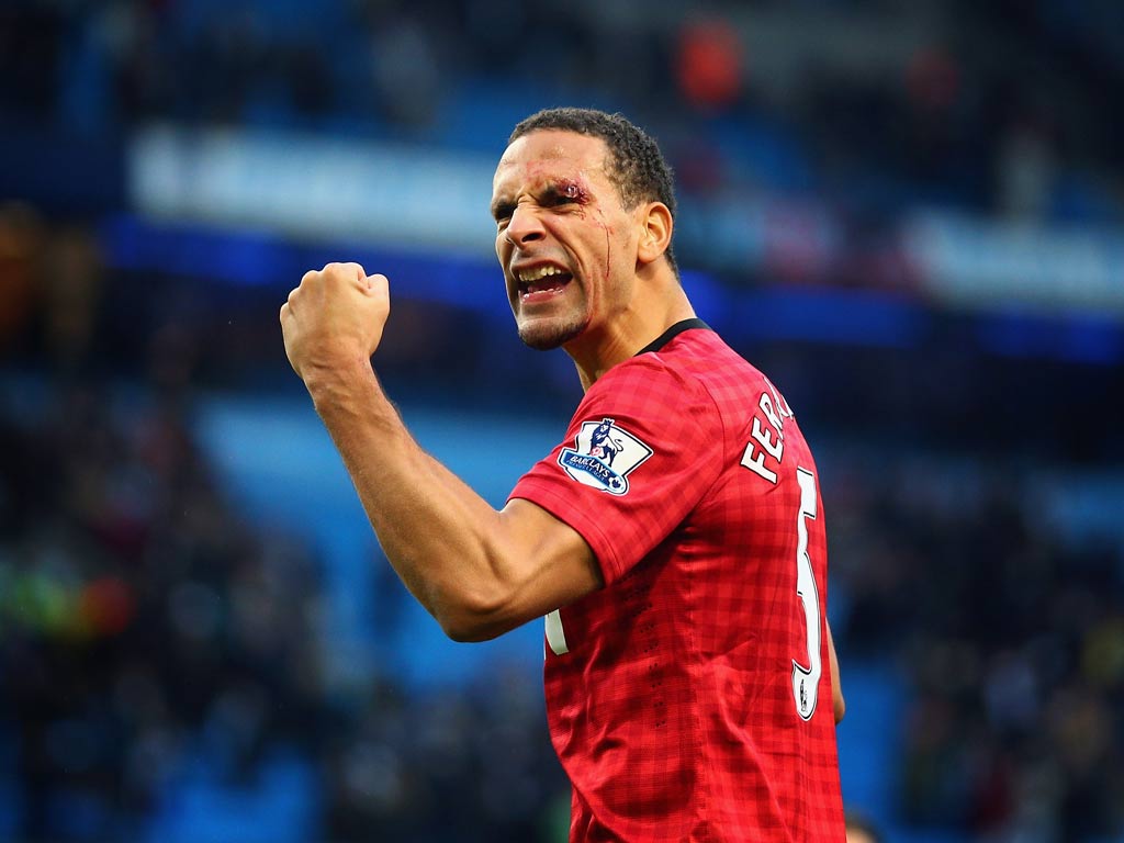 Rio Ferdinand, who was hit by a coin, celebrates victory over Manchester City