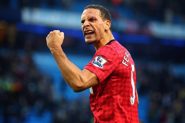 Rio Ferdinand, who was hit by a coin, celebrates victory over Manchester City