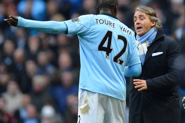 Yaya Toure talks with Roberto Mancini