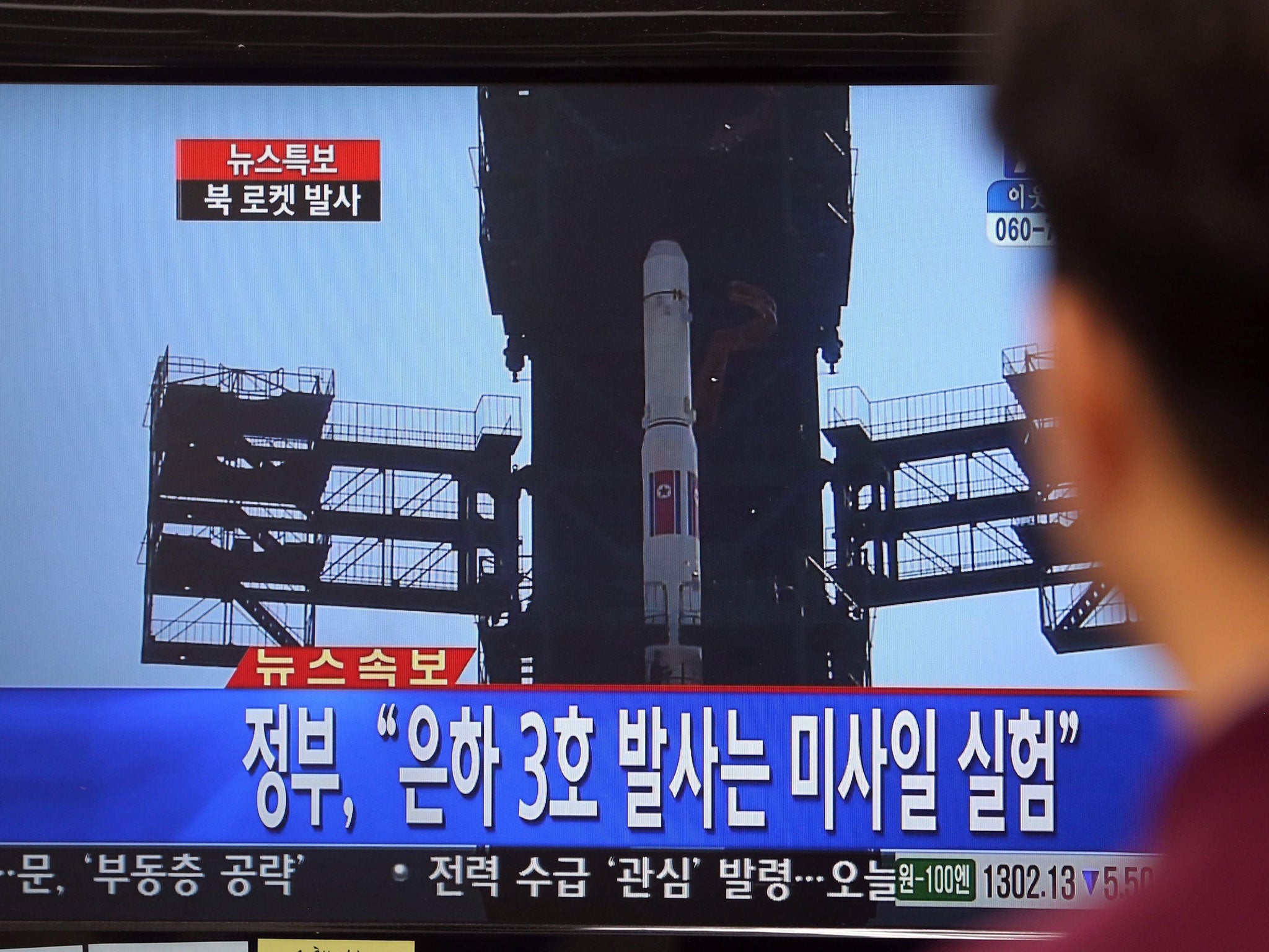 A Seoul citizen watches breaking news on the launch of North Korea's long-range rocket