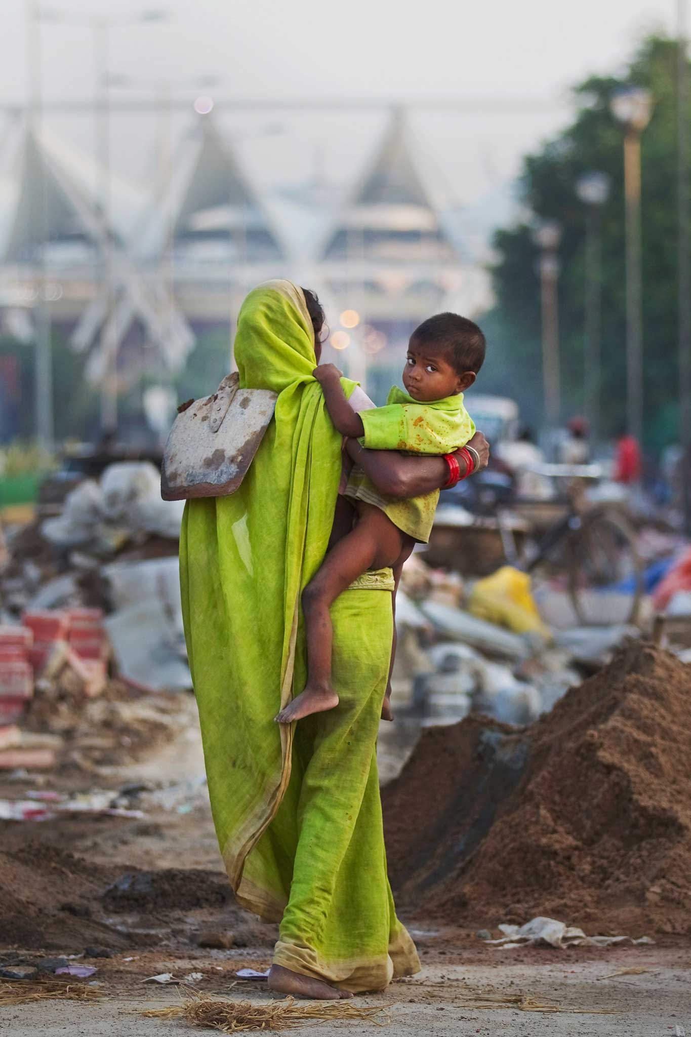 Street life: a labourer with infant and shovel in New Delhi