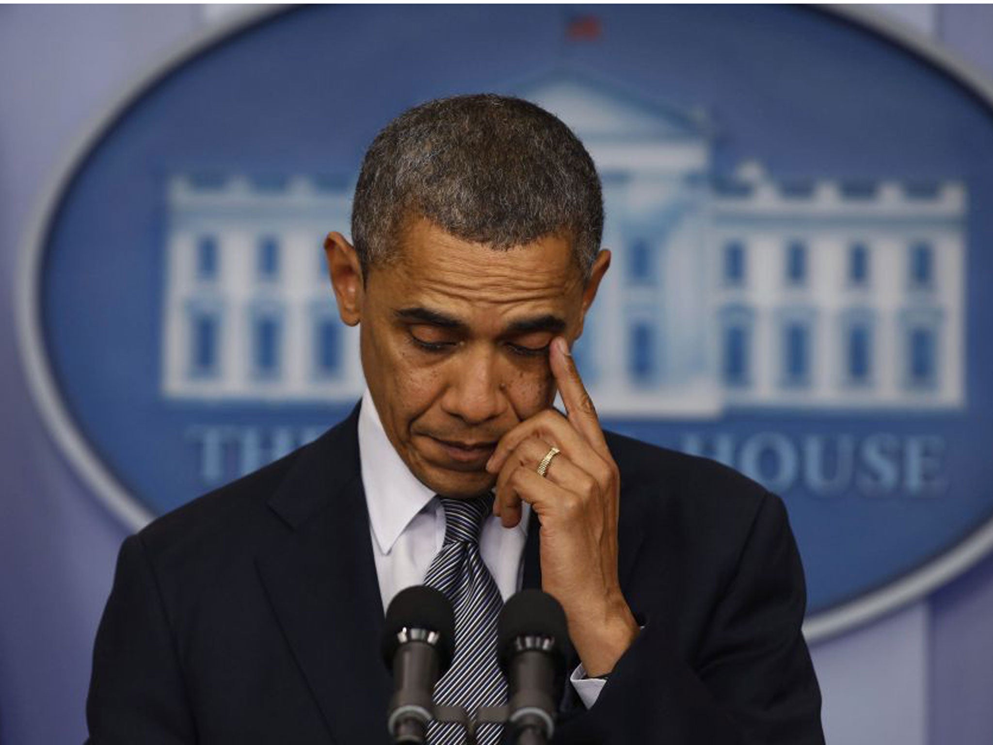 Obama wipes away a tear during the press conference