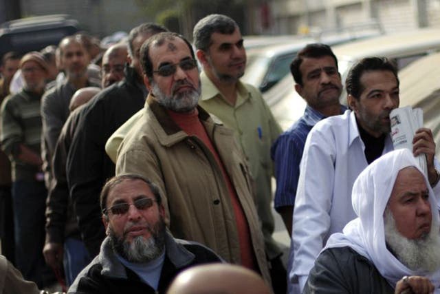 Egyptians wait to cast their votes outside a polling station
