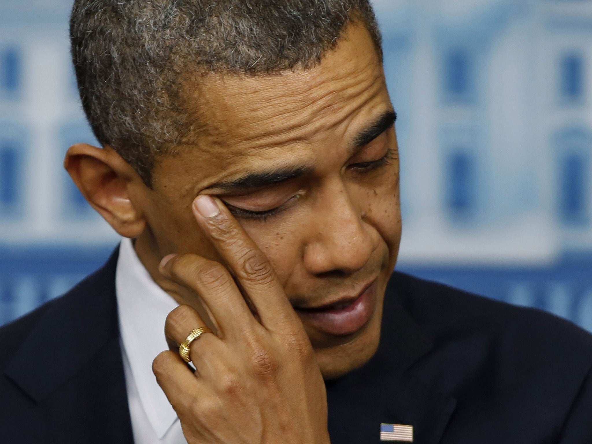 Shaken: President Obama wipes a tear as he speaks about the shootings in Newtown, Connecticut