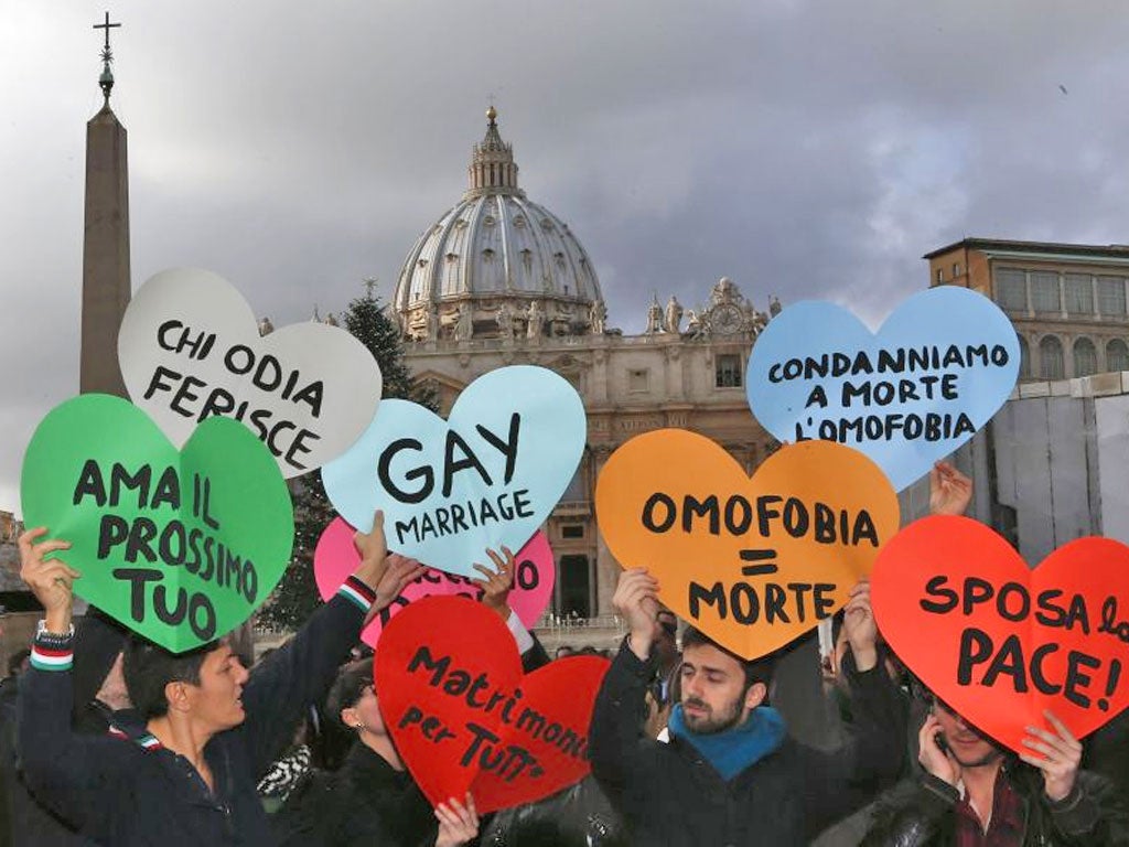 Members of a gay activist group hold signs in front of St. Peter's square in the Vatican
