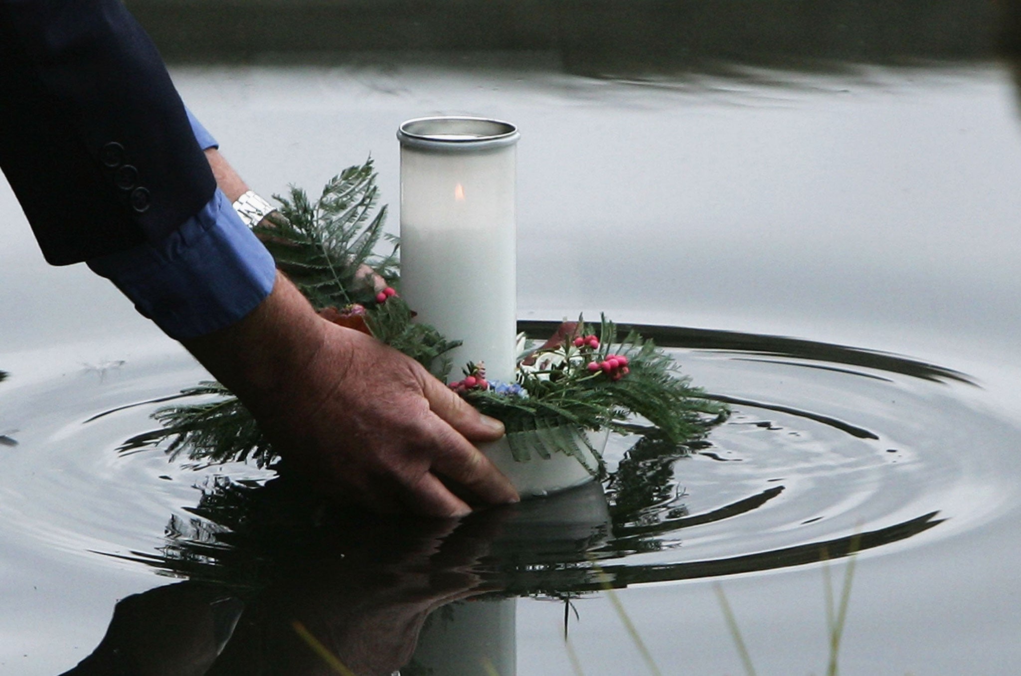 Keith Moulton, whose daughter and two grand daughters were killed at the Port Arthur massacre, lays a floating candle in the reflection pool at the memorial site during a memorial service to mark the 10th aniversary of the massacre April 28, 2006 in Port Arthur, Australia.