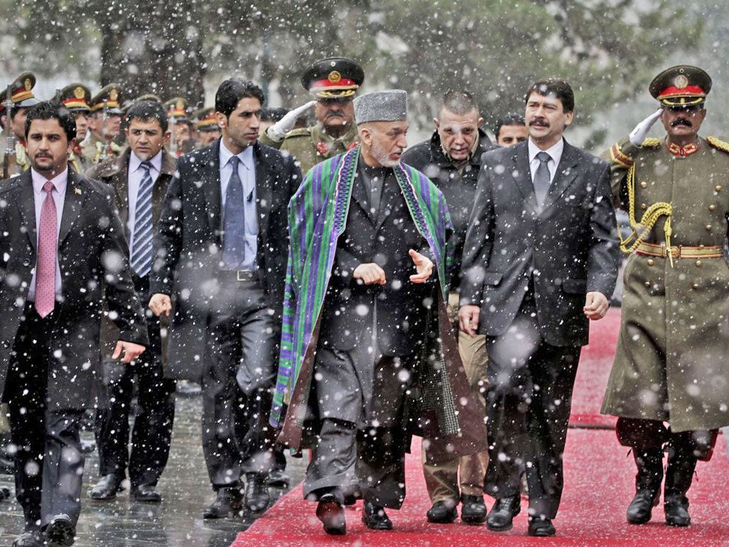 Hungarian President Janos Ader, second right, looks at guards of honor with Afghan President Hamid Karzai after his arrival at the presidential palace in Kabul, Afghanistan