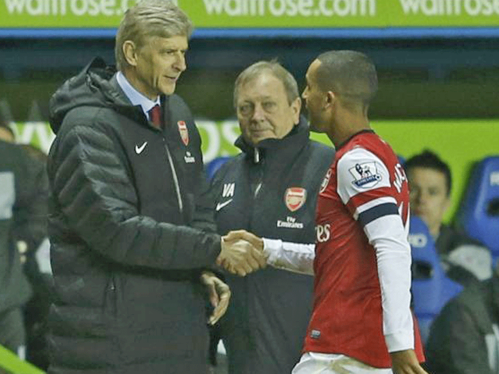 Theo Walcott shakes hands with Arsène Wenger after being
substituted last night
