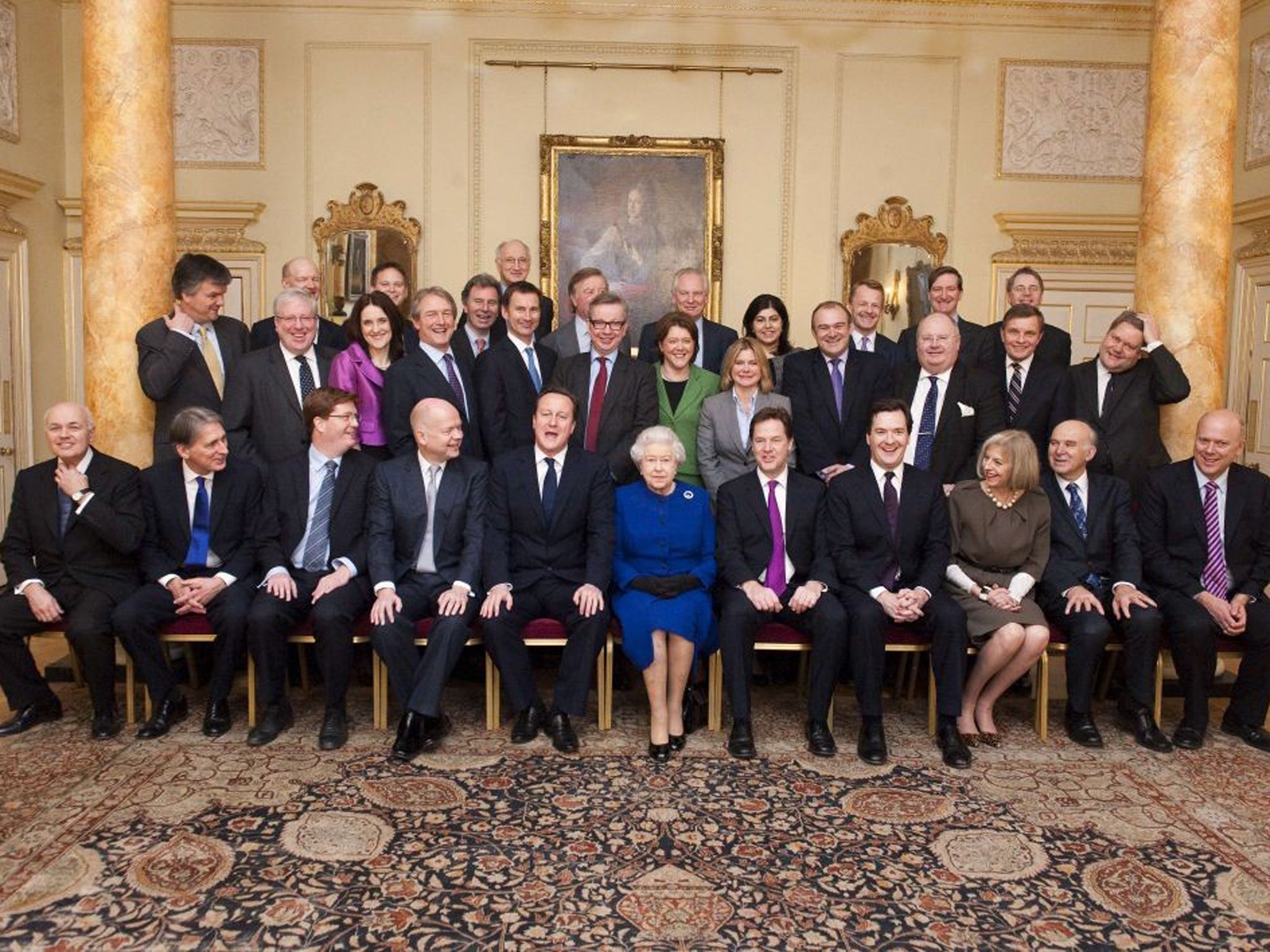 The Queen sits among members of the Cabinet today, flanked by David Cameron and Nick Clegg