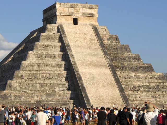 Tourists gather underneath the pyramid of Chichen Itza in Merida, southern Mexico