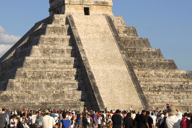 Tourists gather underneath the pyramid of Chichen Itza in Merida, southern Mexico