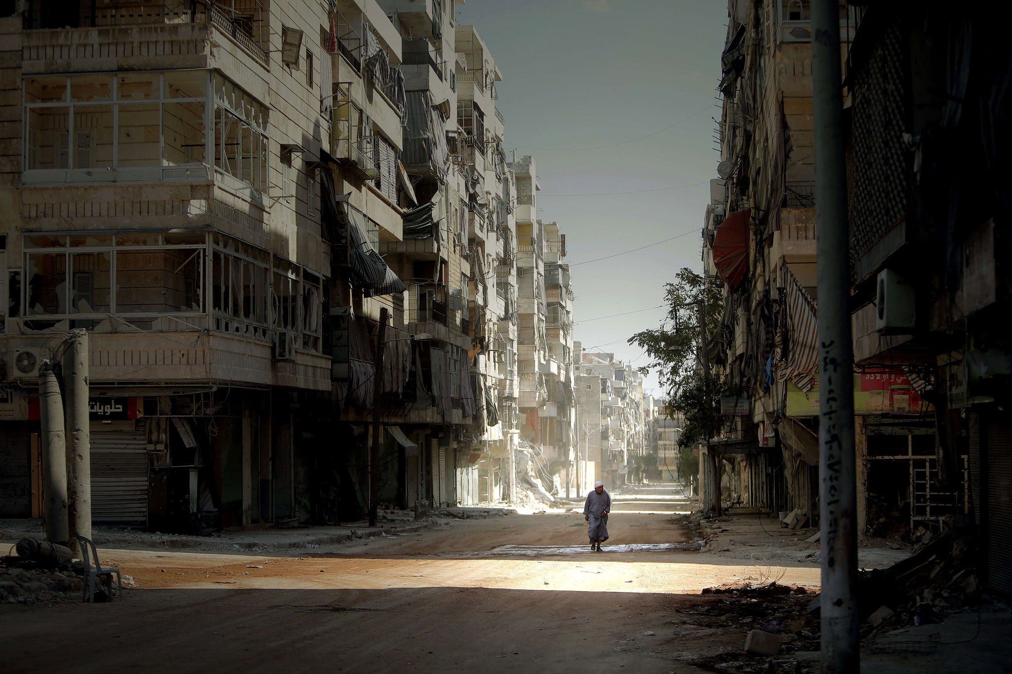 A Syrian man walks through a ravaged part of Aleppo in September