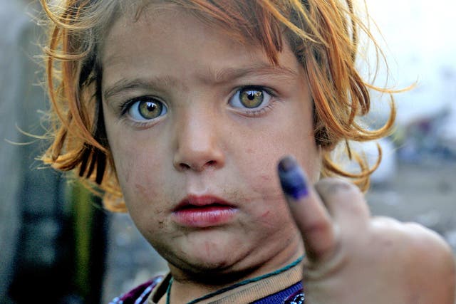 A girl with a marked finger after being immunised in Lahore