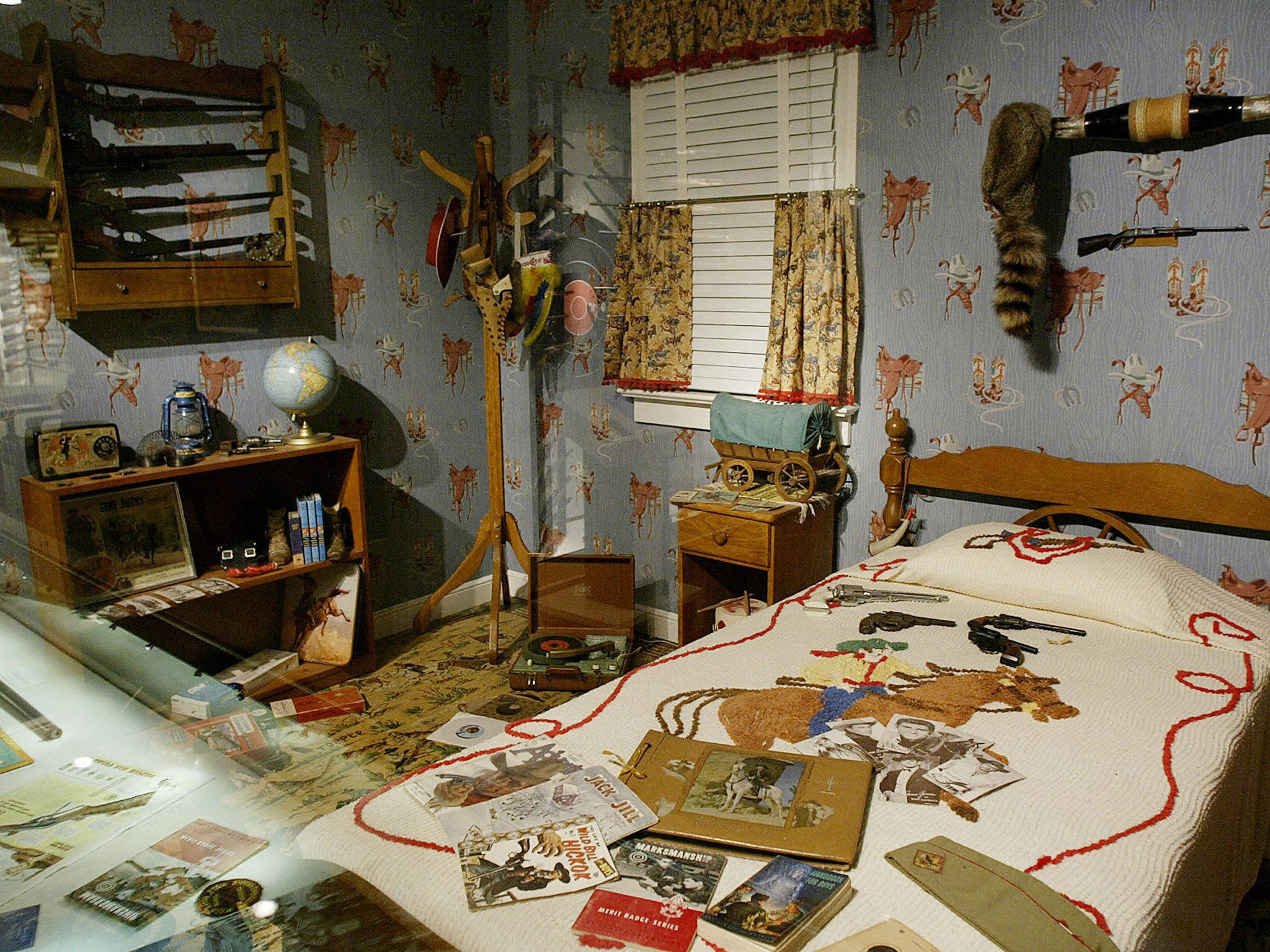 FAIRFAX, UNITED STATES: An exhibit showing a decades old boys room complete with toy guns on the bed and real guns designed for children on the wall