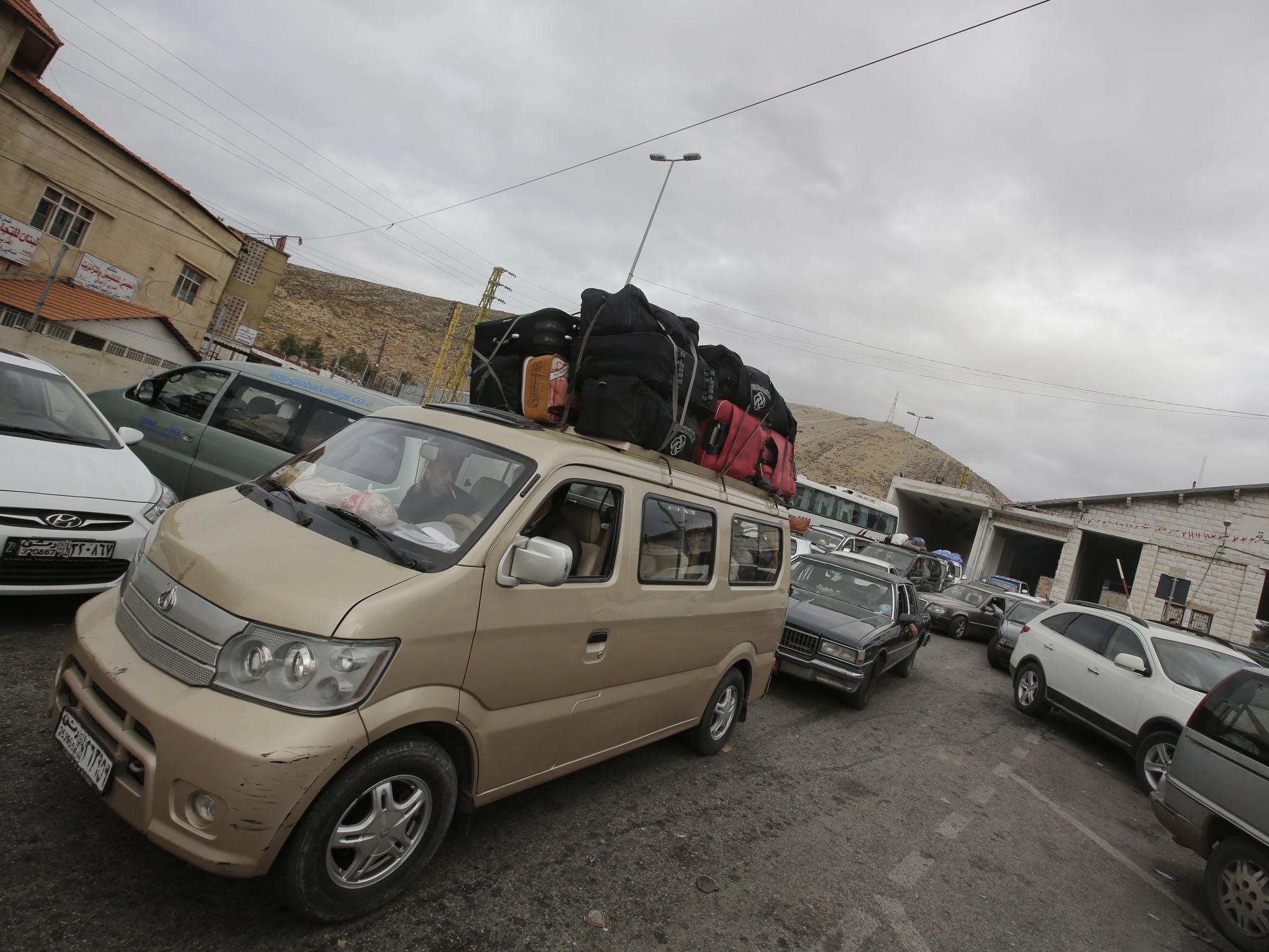 Palestinians and Syrians who fled violence in their country are seen at the Masnaa Lebanese border crossing with Syria as people stamp their documents before entering Lebanon on December 19, 2012. A large number of Palestinians refugees and others who fle