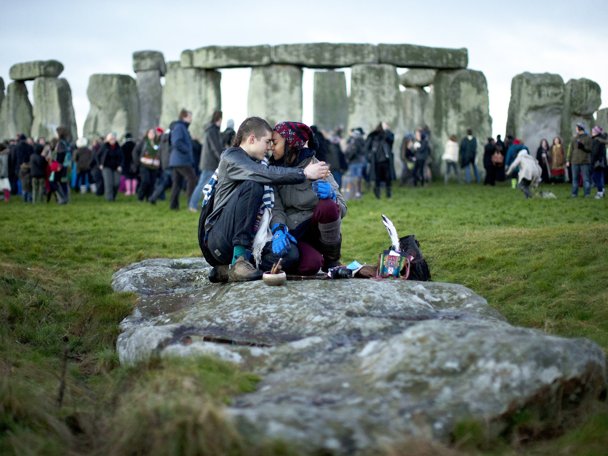 People embrace by the ancient stone circle of Stonehenge, in southern England, as access to the site is given to druids, New Age followers and members of the public on the annual Winter Solstice on 21 December 2012