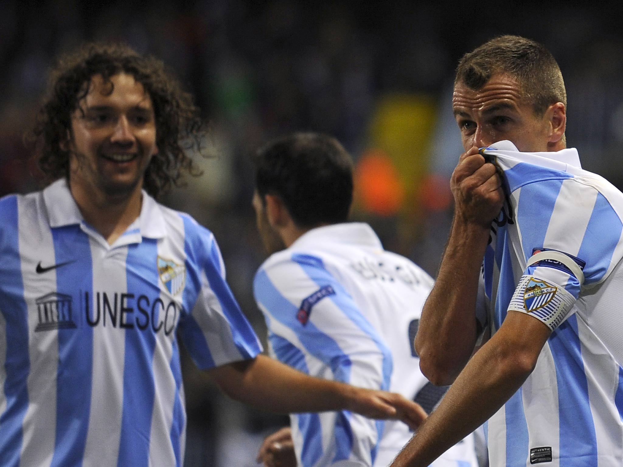 Malaga's Portuguese midfielder Duda celebrates with his teammates after scoring during the Champions League Group C match Malaga against Anderlecht