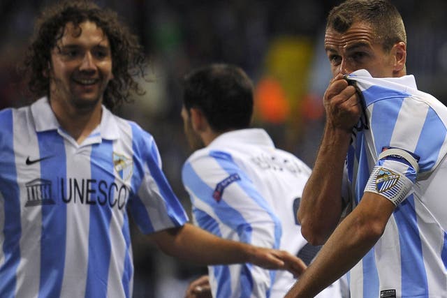 Malaga's Portuguese midfielder Duda celebrates with his teammates after scoring during the Champions League Group C match Malaga against Anderlecht
