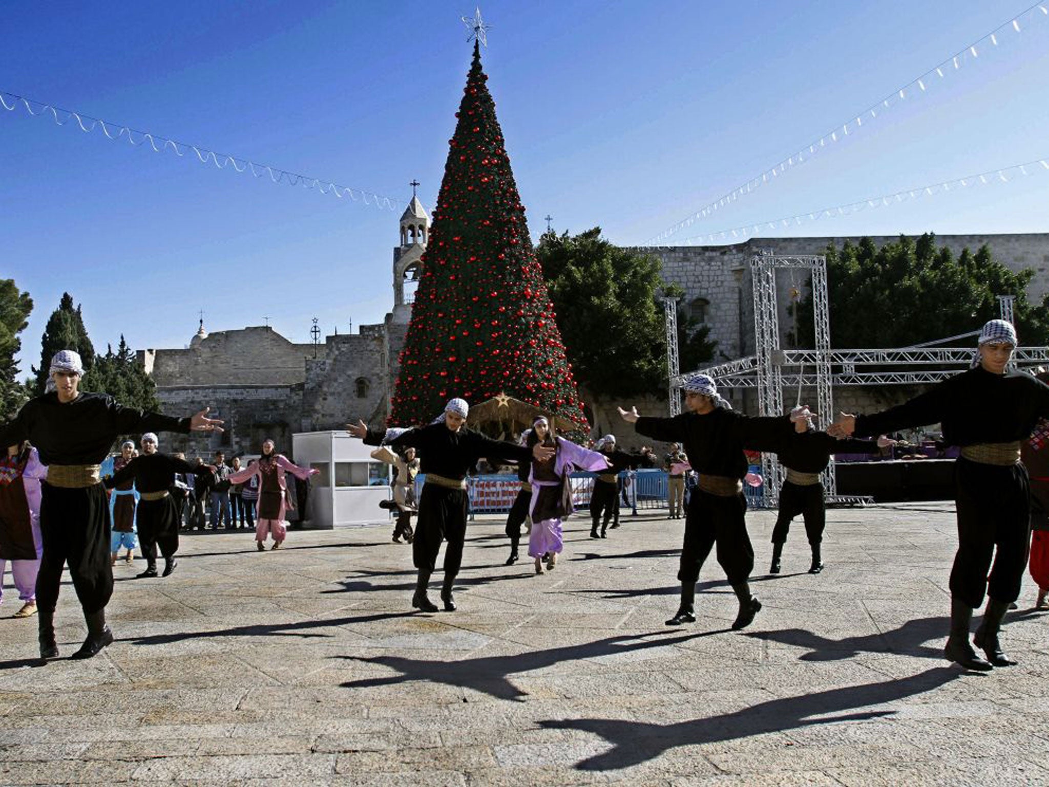 Palestinian dancers perform outside the Church of Nativity