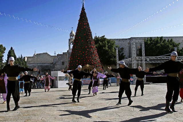 Palestinian dancers perform outside the Church of Nativity
