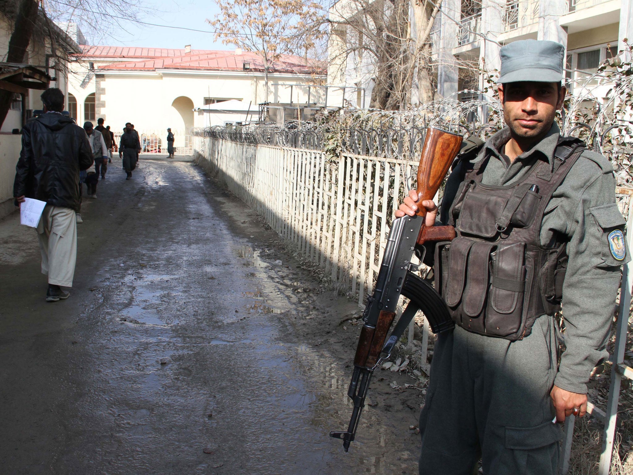 Afghan police stand guard outside the police compound where an Afghan policewoman shot dead a US military adviser