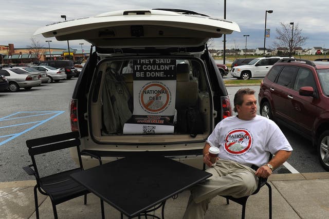 Scott Soucy sits in front of a Starbucks in Middletown, Del., waiting to engage people. His usual opening line is: "Hi there, do you want to talk about the national debt?" Most are skeptical of his plan. 