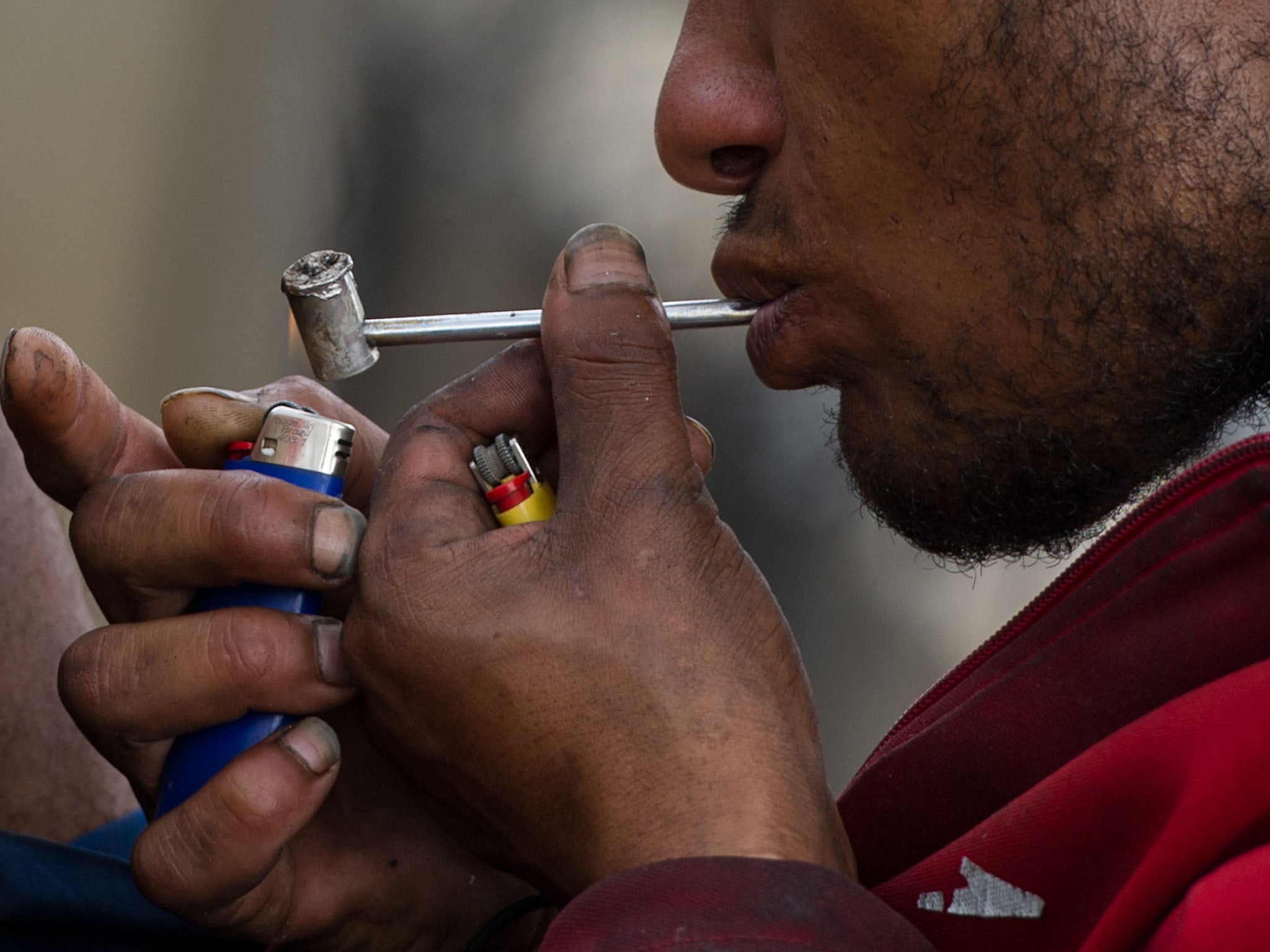 A drug addict smokes crack on the street in an area called 'Cracolandia' (Crackland in English), in downtown Sao Paulo, Brazil