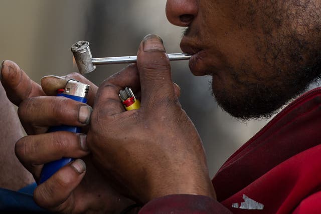 A drug addict smokes crack on the street in an area called 'Cracolandia' (Crackland in English), in downtown Sao Paulo, Brazil 
