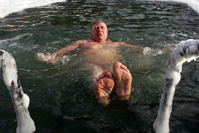 A man enjoys swimming in icy water of a frozen park pond in Moscow, 24 February 2007.