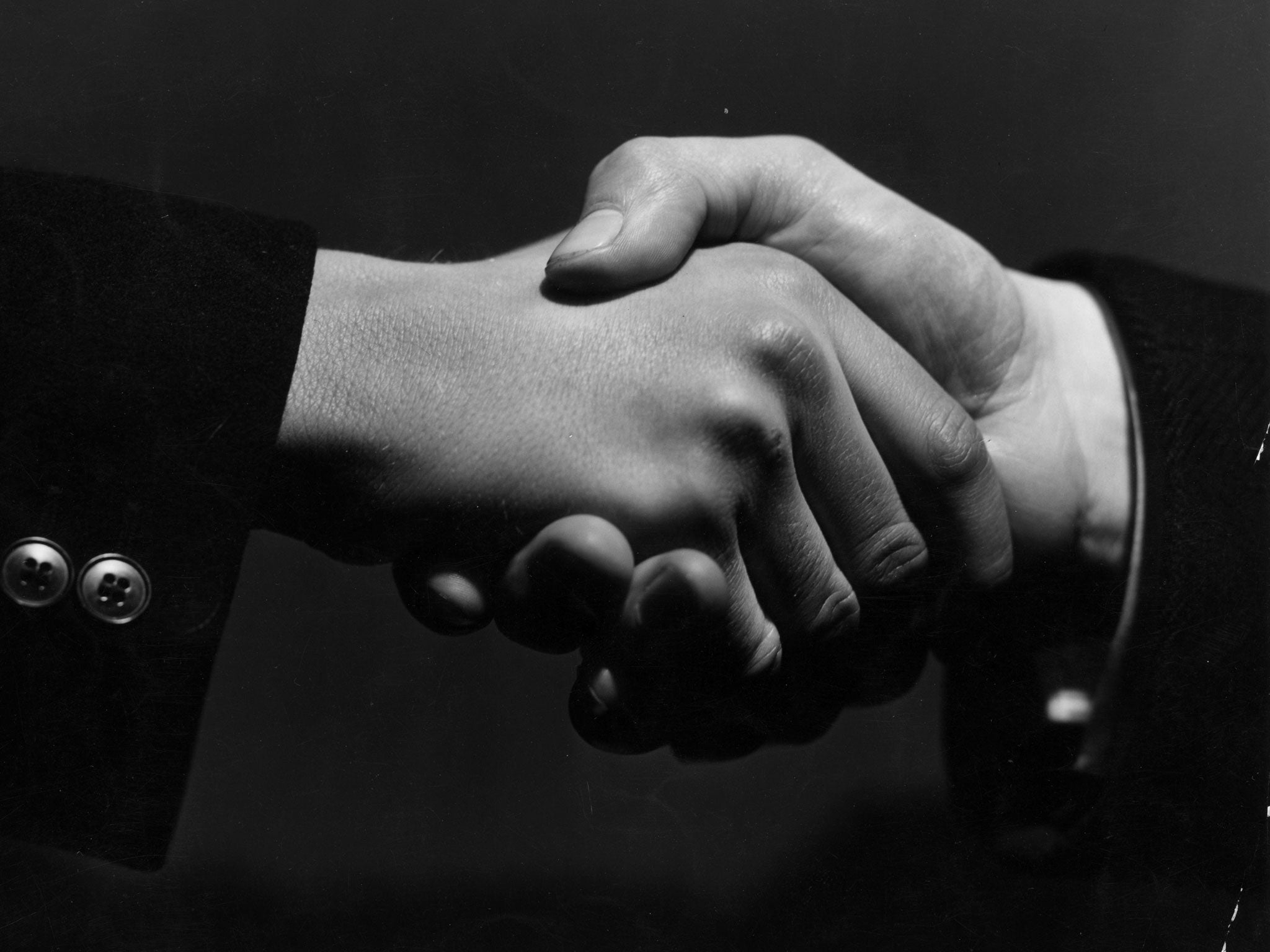 16th February 1938: A close-up of two hands grasping each other in a firm handshake.