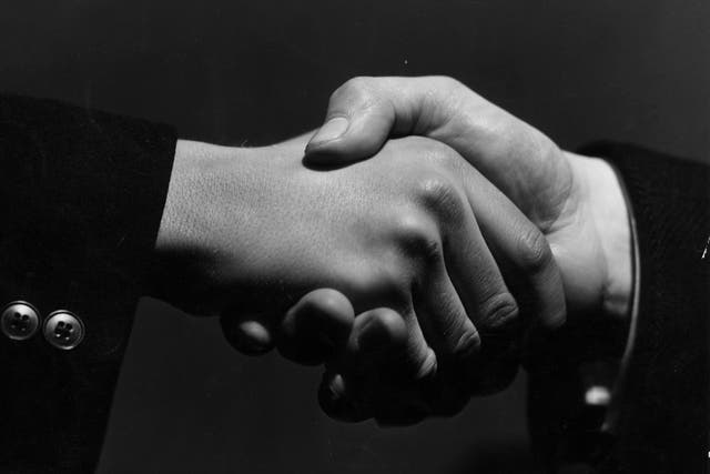 16th February 1938: A close-up of two hands grasping each other in a firm handshake.