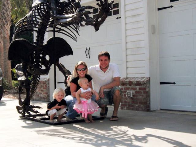 Eric Prokopi and his family pose under a dinosaur skeleton