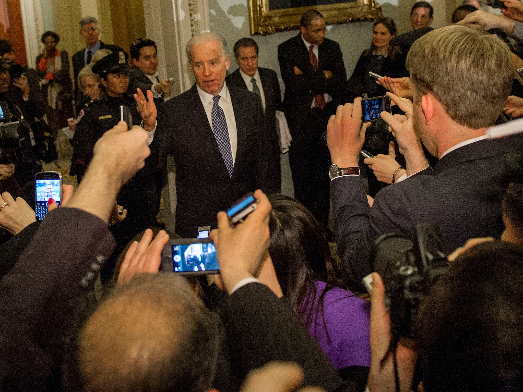 US Vice President Joe Biden talks with reporters in the halls of the US Senate after attending a Democrat Caucus on solving the impending fiscal cliff.