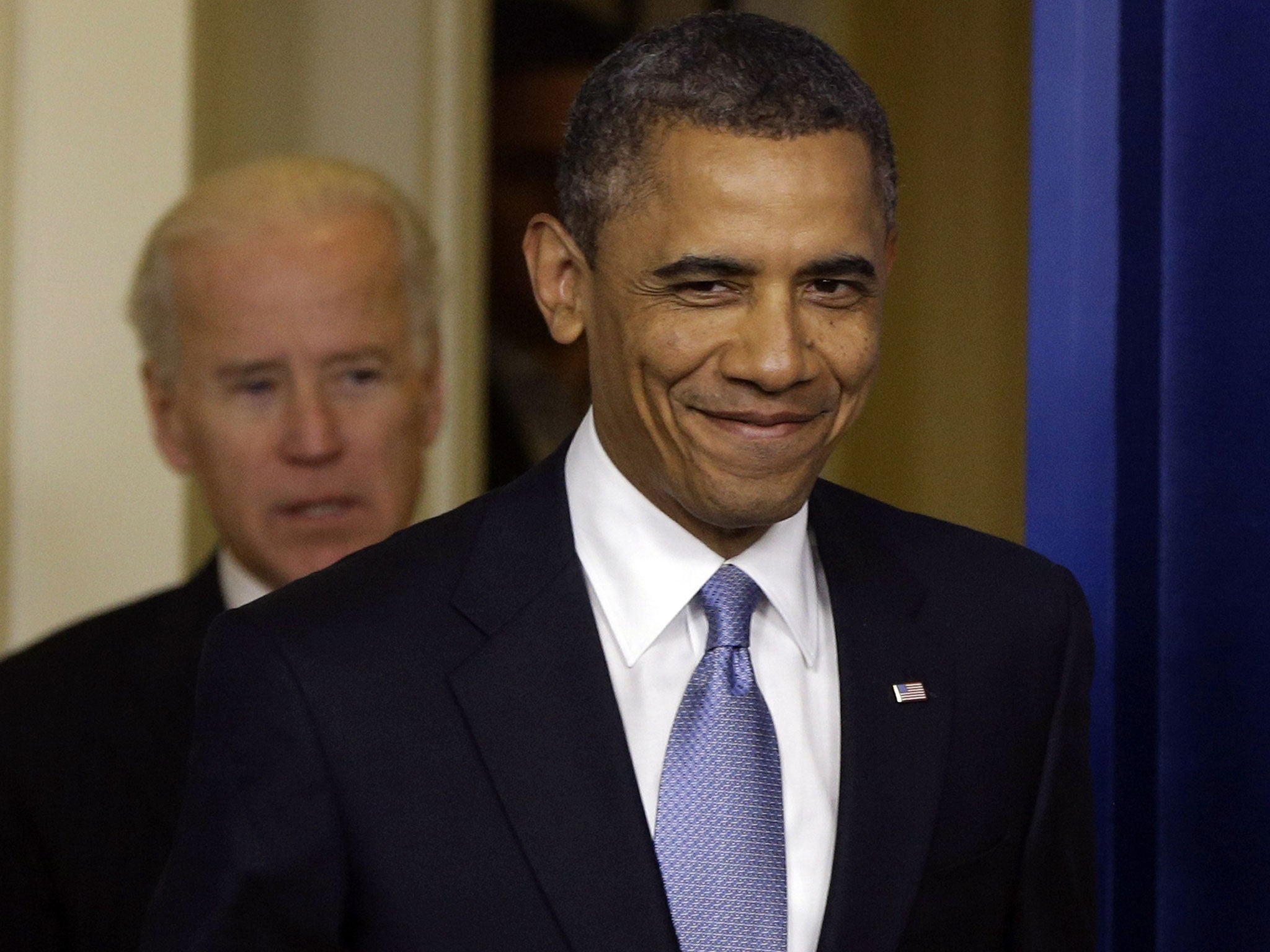 President Barack Obama smiles as he arrives with Vice President Joe Biden to make a statement the fiscal cliff bill is passed